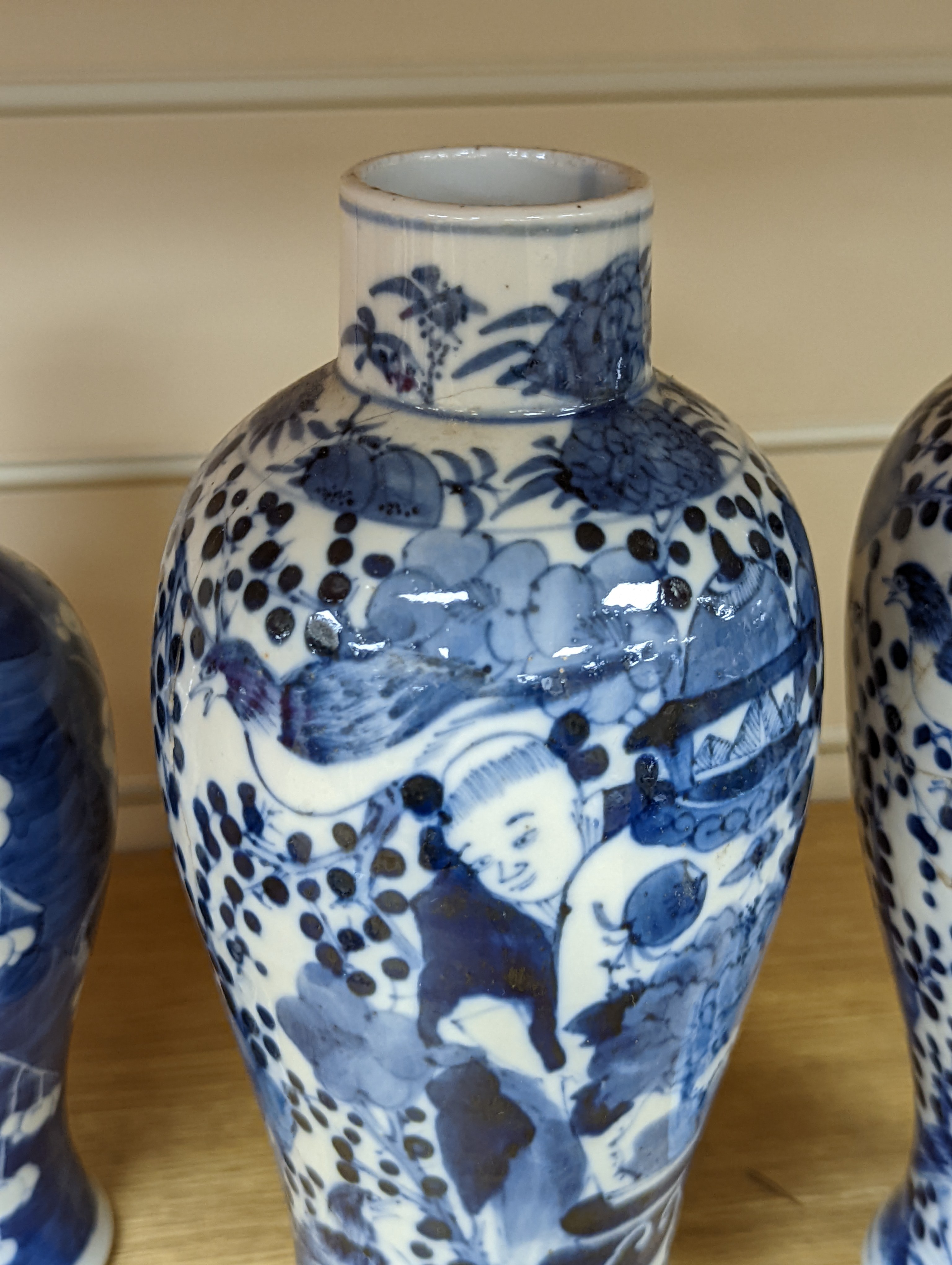 A pair of 19th century Chinese blue and white vases, a prunus vase and cover and a similar jar (4), pair of vases 24 cms high.